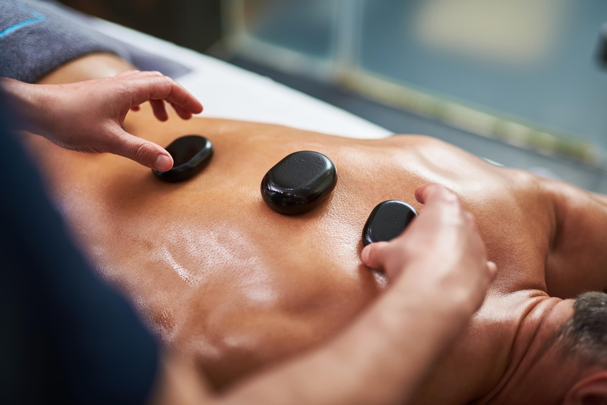 Gydomasis masažas karštais akmenimis su aromaterapiniu aliejumi